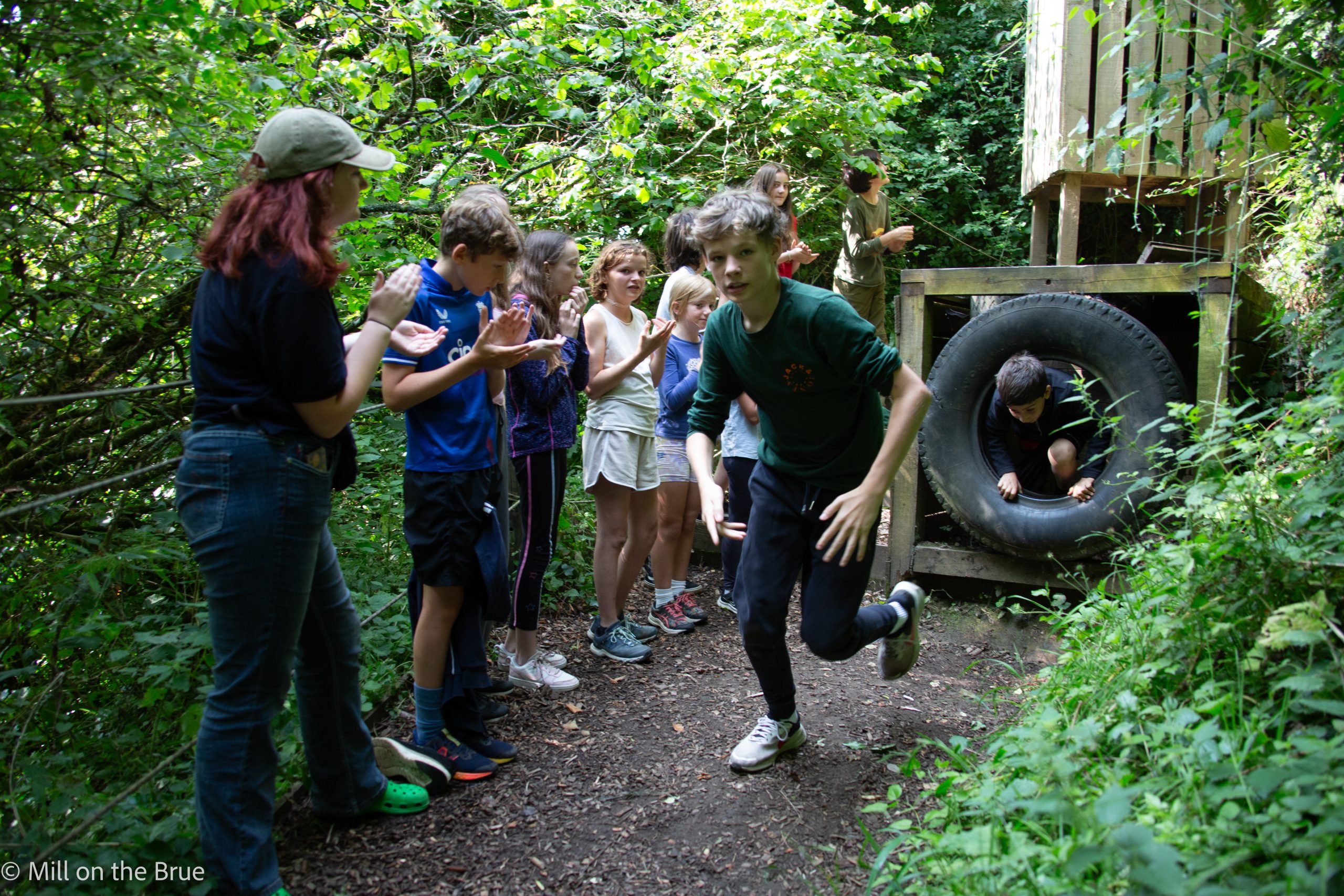 Children cheer as their classmates race through an obstacle course.