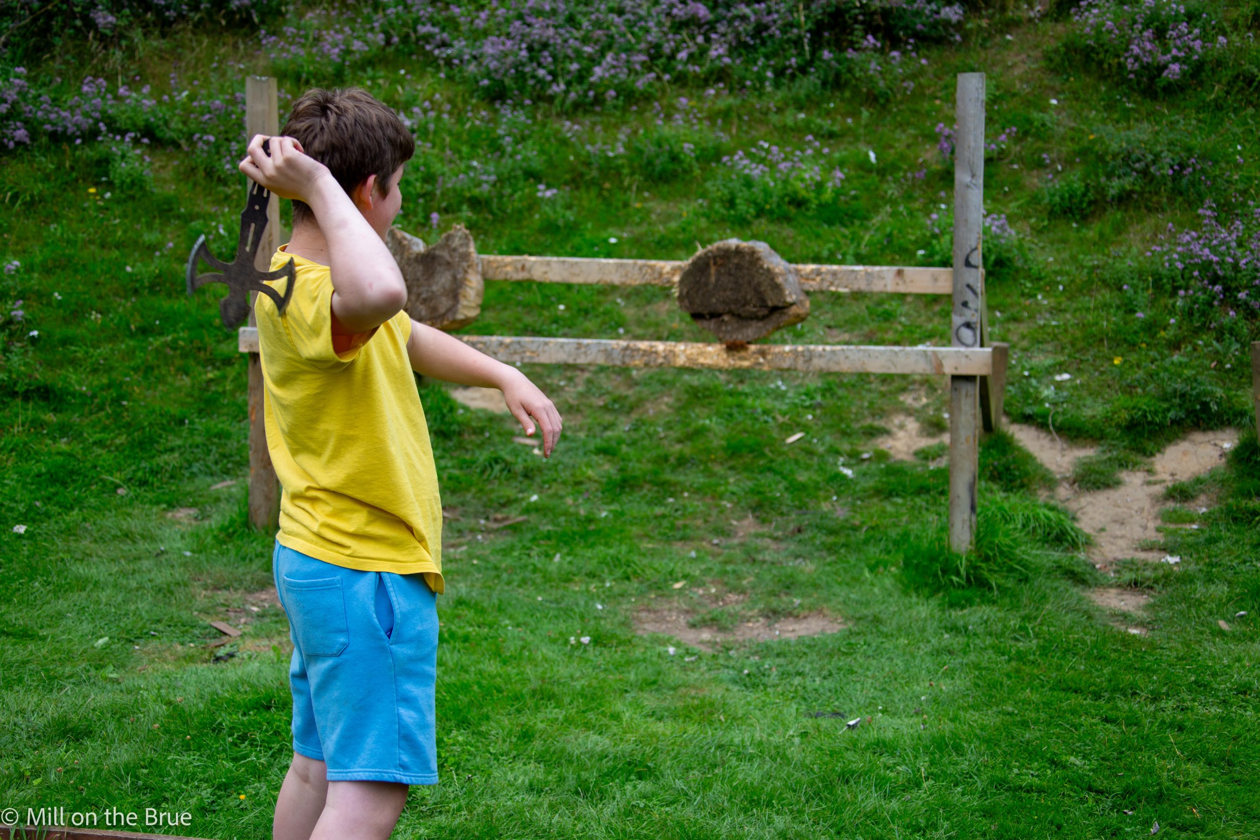 A student throws an axe at a target.