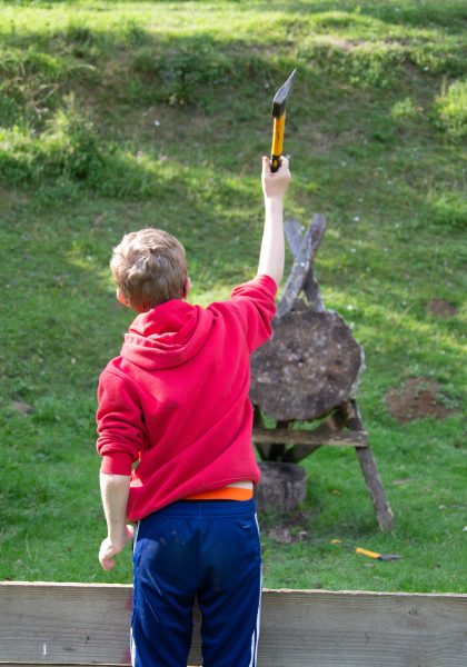 A student throws an axe at a target.