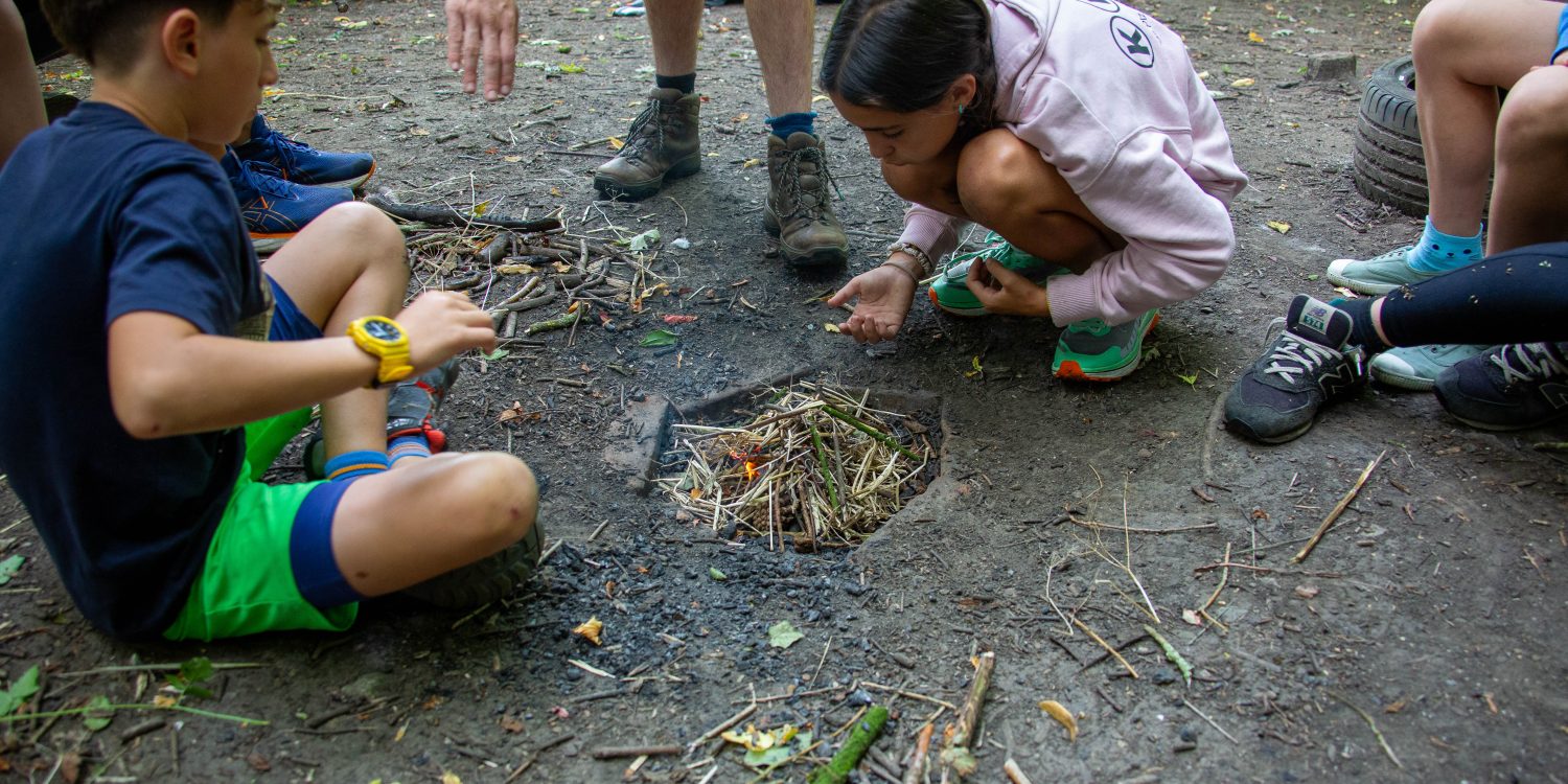 Students starting a campfire.
