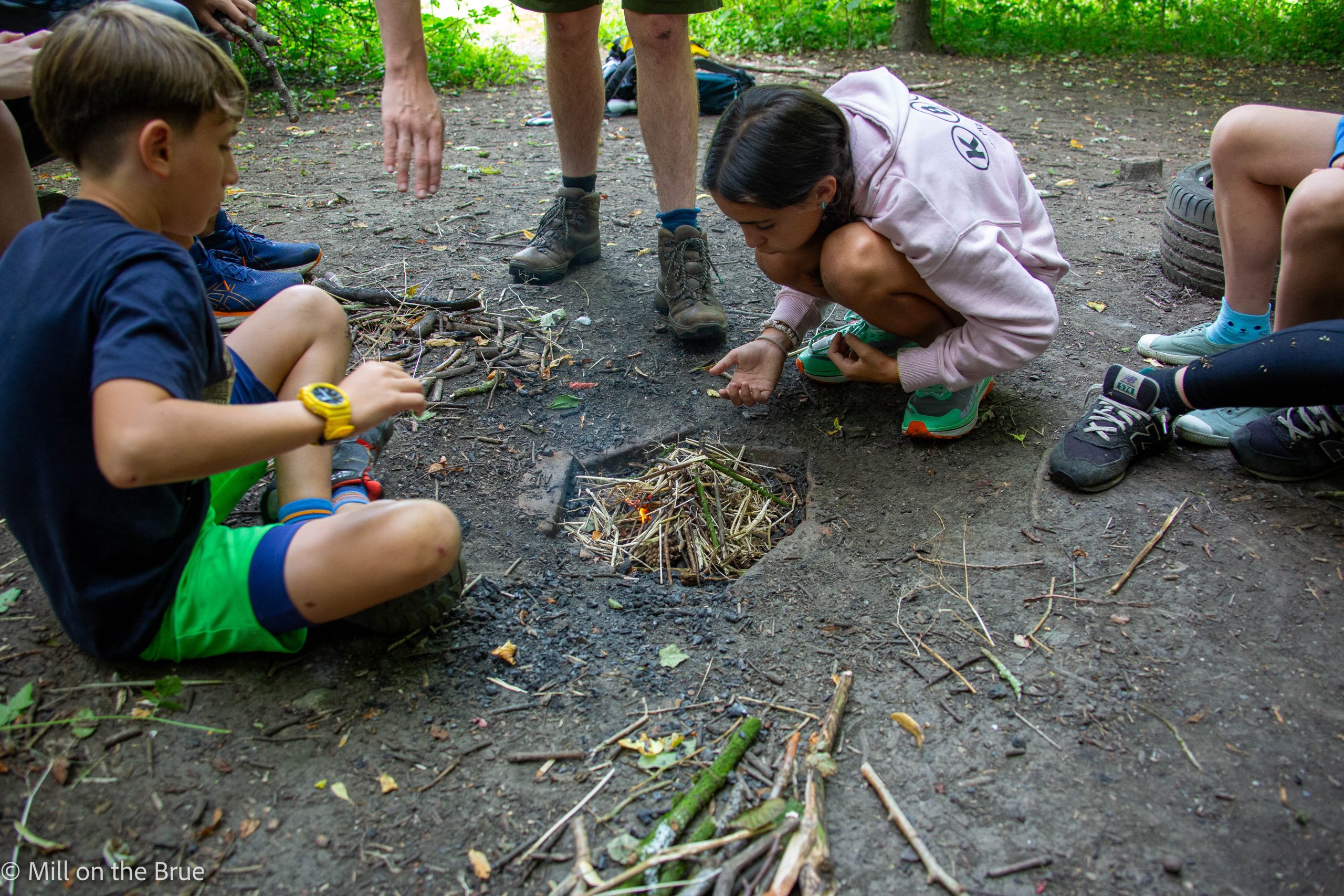 Students starting a campfire.