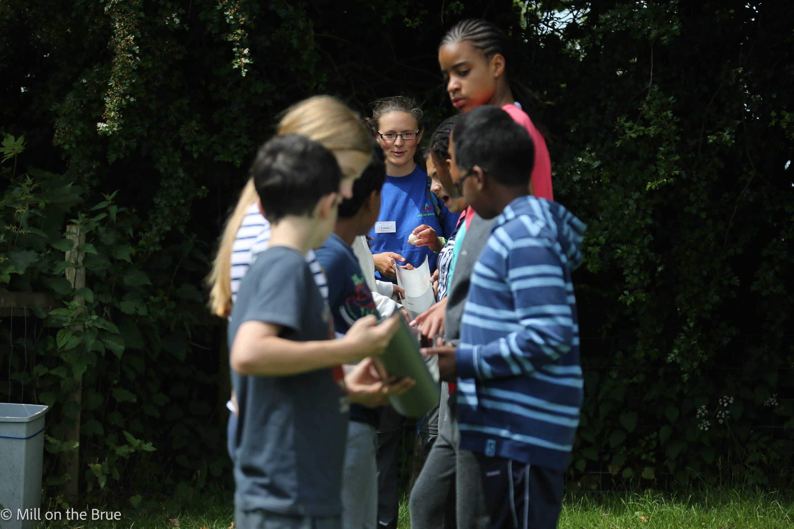 Students guide a ball down a series of ramps.