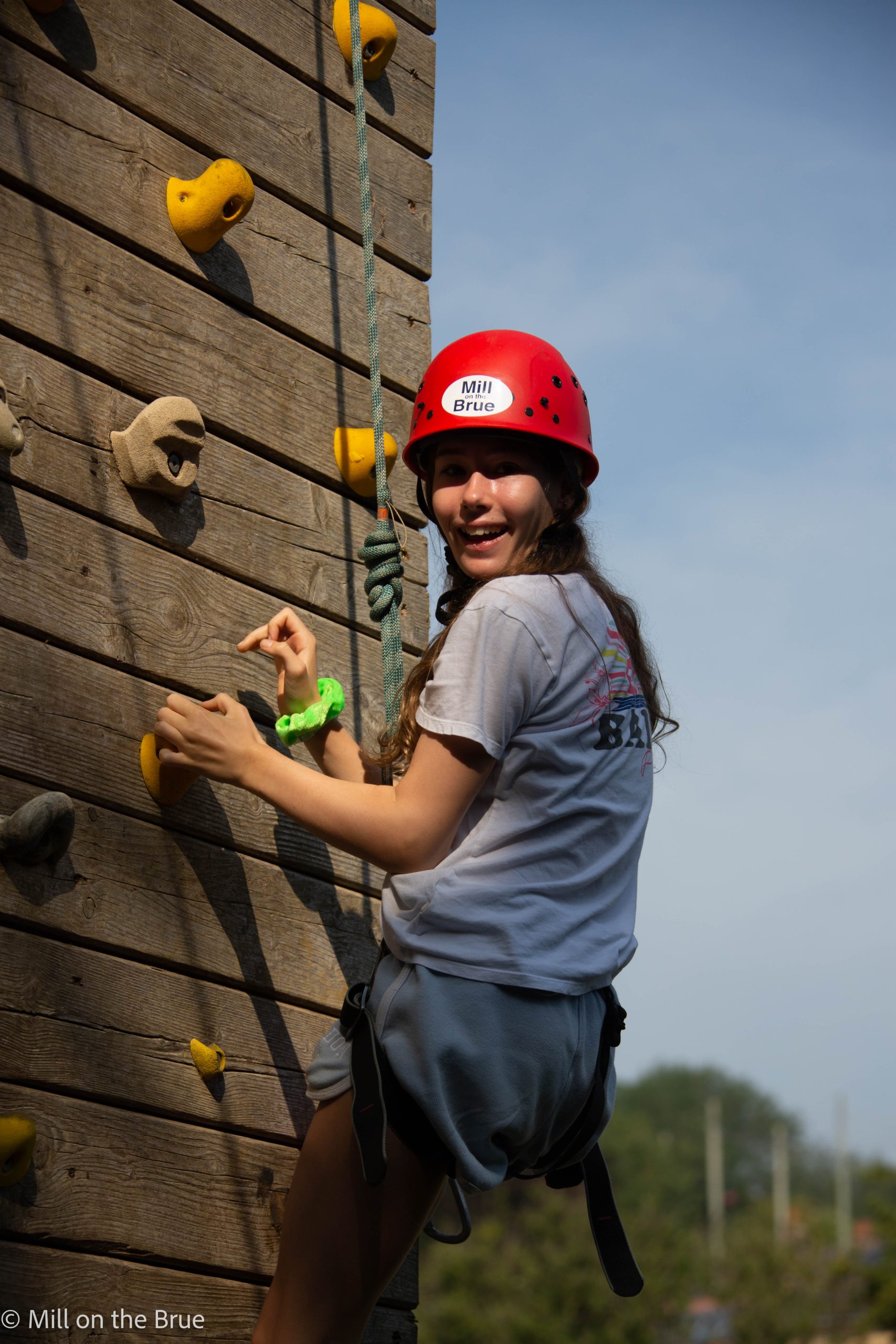 Teen on a wooden climbing wall.