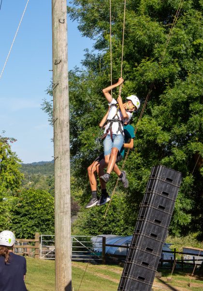 Students fly through the air on ropes and pulleys.
