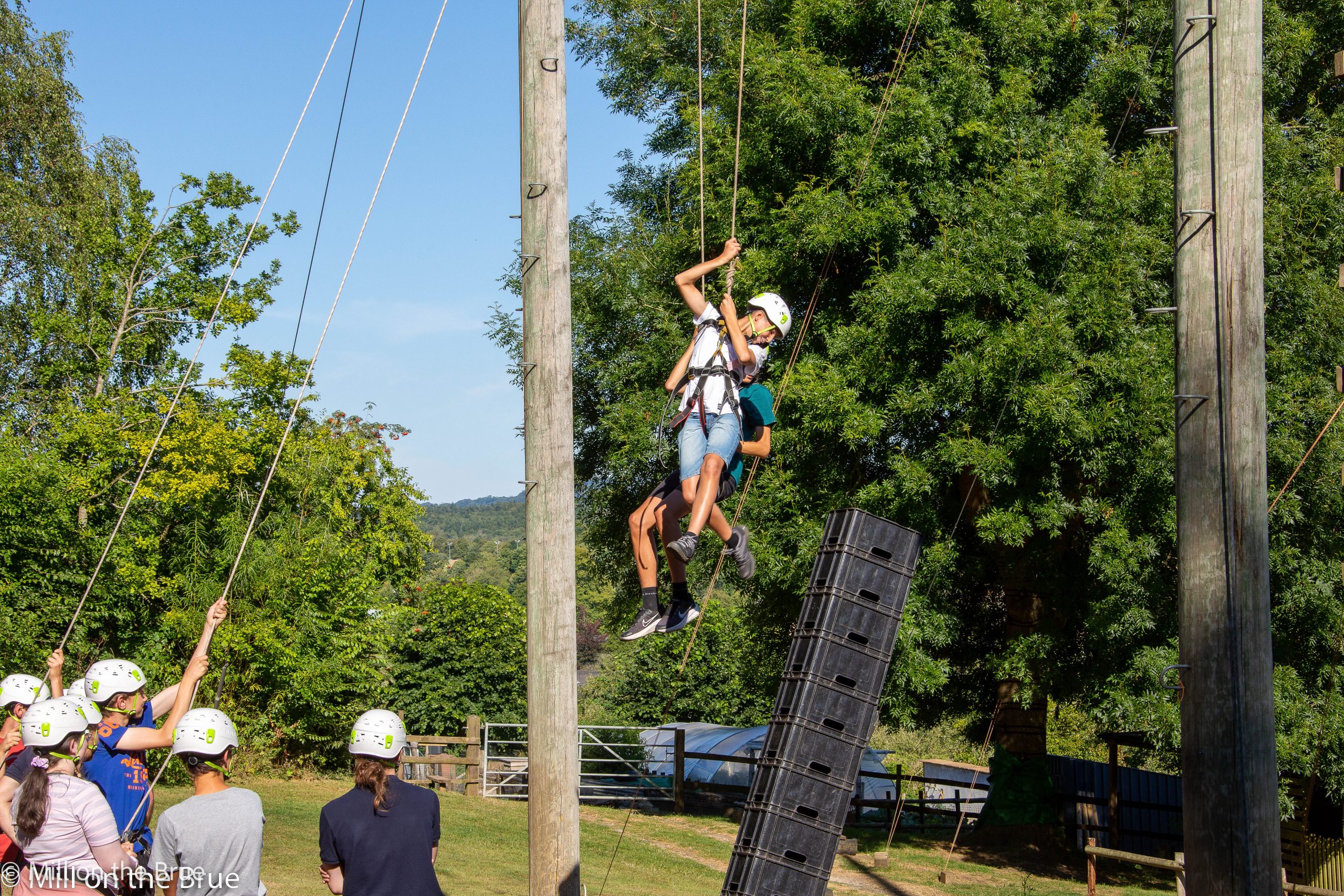Students fly through the air on ropes and pulleys.