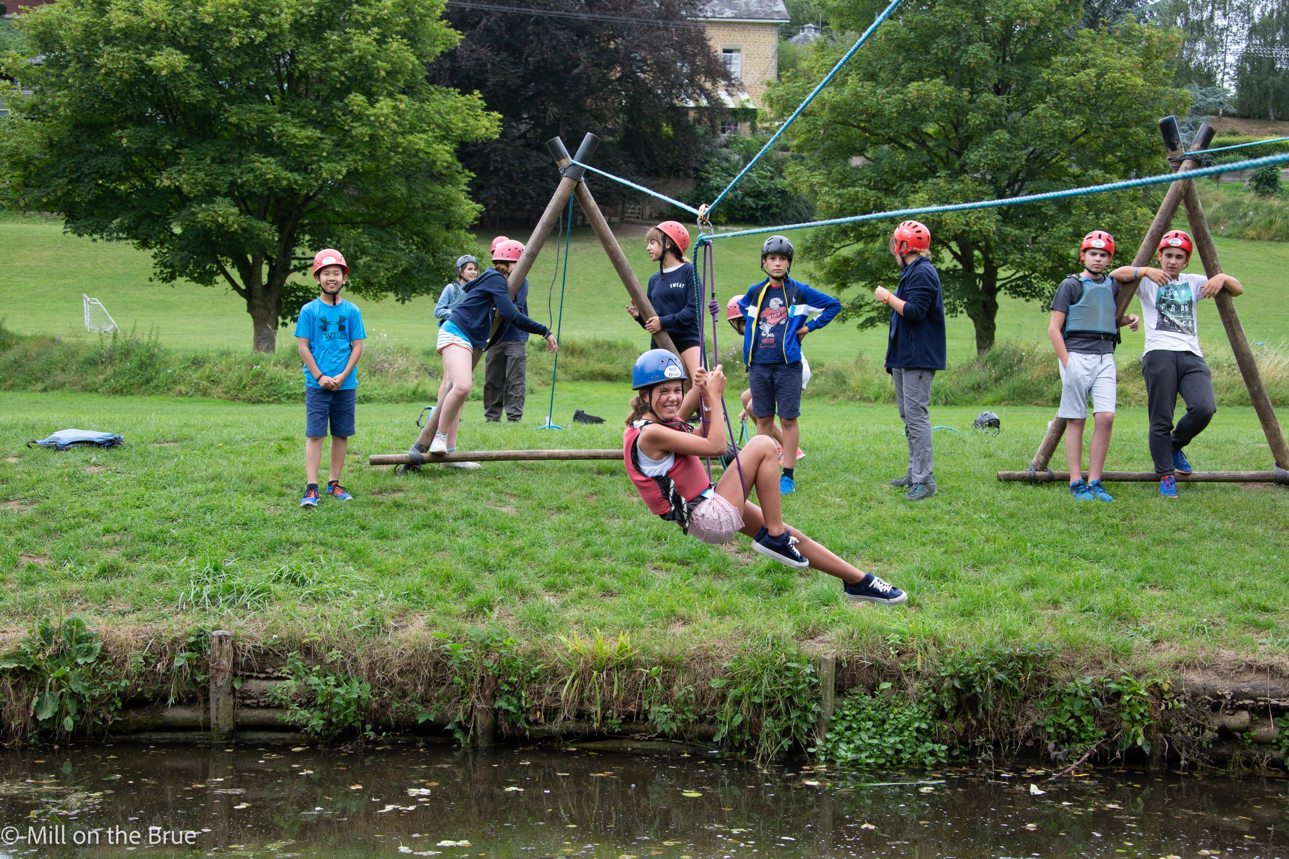 Child crosses a river on a rope.