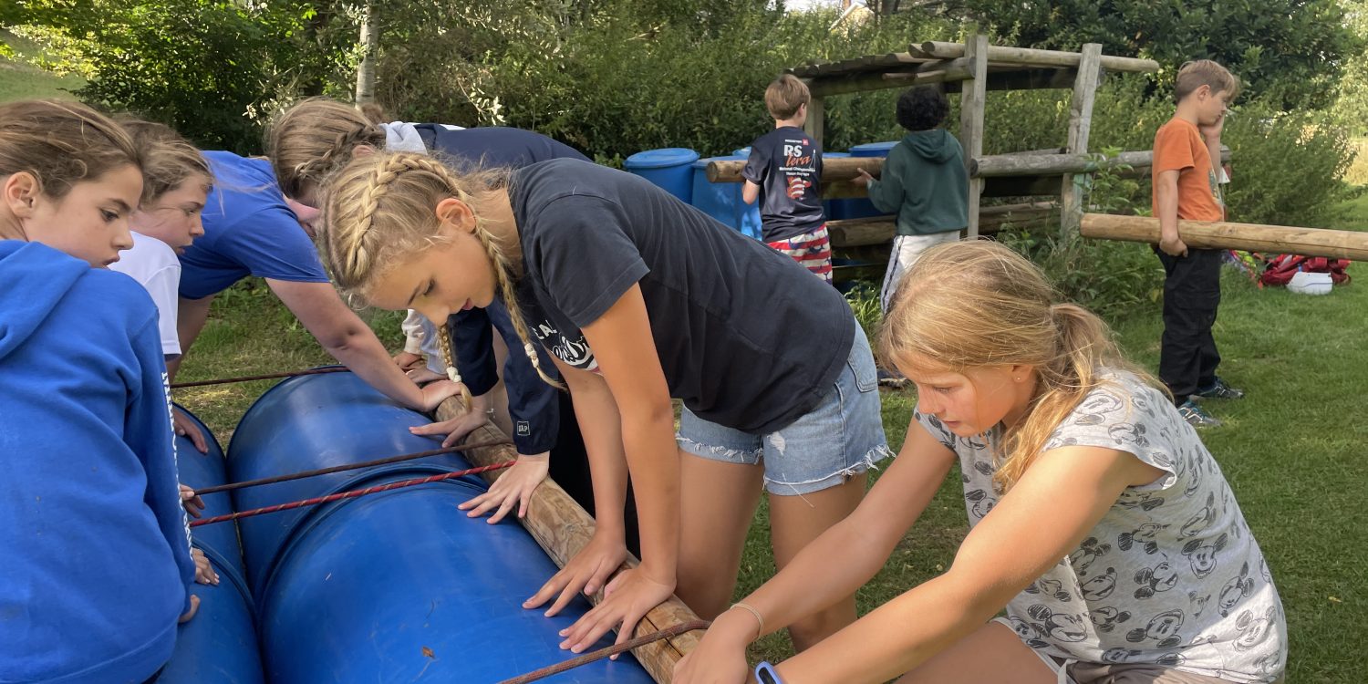 Students construct rafts of barrels and rope.