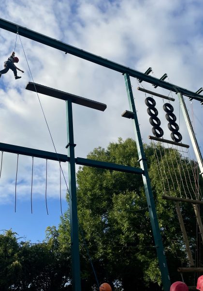 A child scales a large suspended obstacle course.