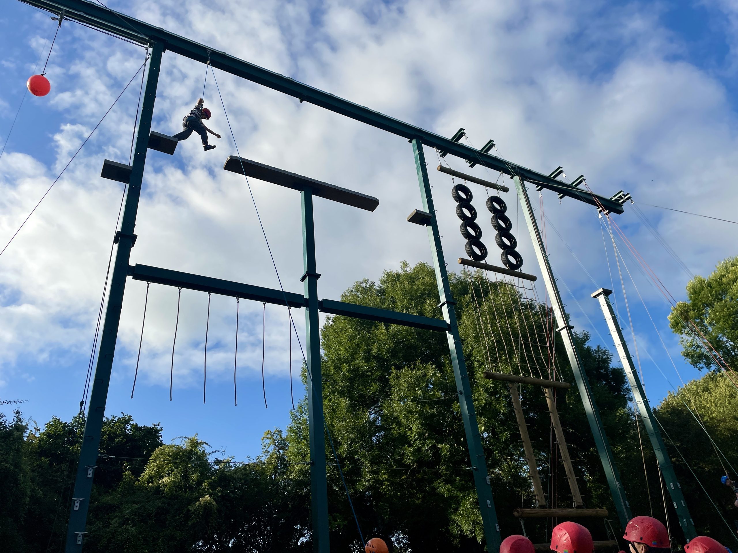 A child scales a large suspended obstacle course.